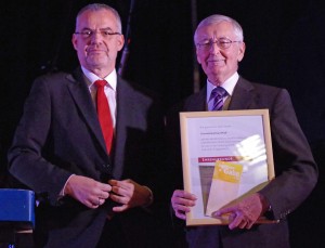 Der Präsident des Schwäbischen Chorverbands, Dr. Jörg Schmidt (links), hatte die Ehrenurkunde sowie einen Scheck dabei. Foto: Krytzner